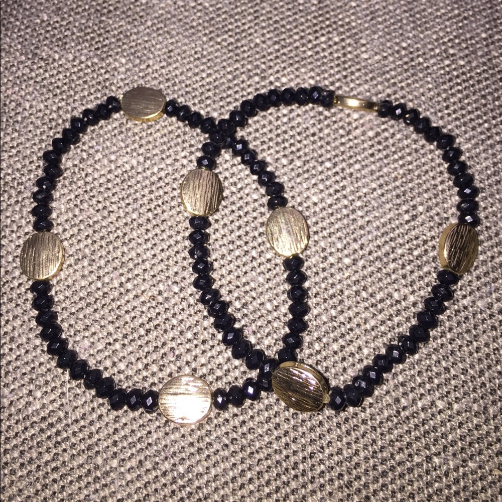 2 black and gold beaded bracelets