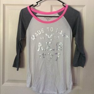 A white and gray half sleeve American eagle shirt.