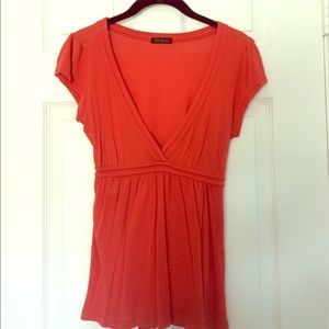 Flowy orange plunging neck shirt.