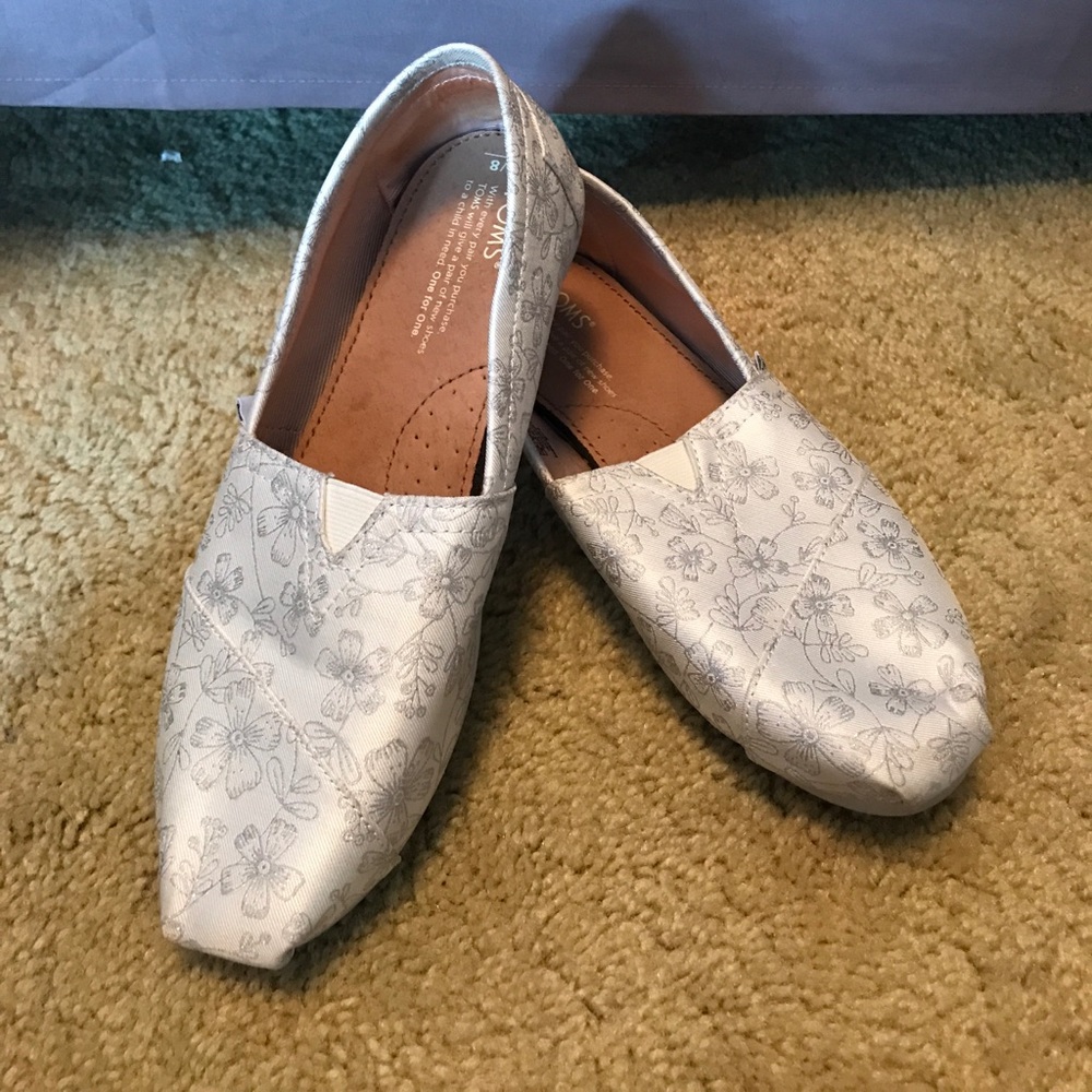 White Toms with silver floral embroidery.