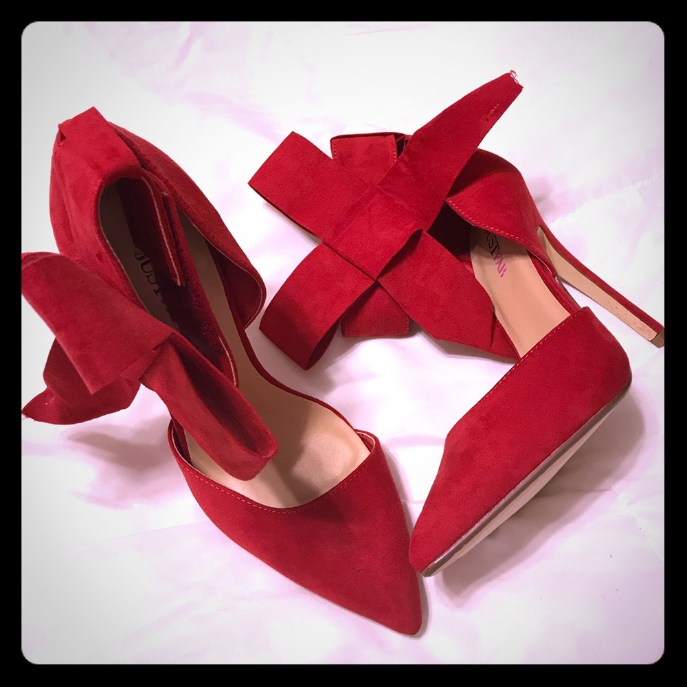 Red elegant heels with bow on the ankle.