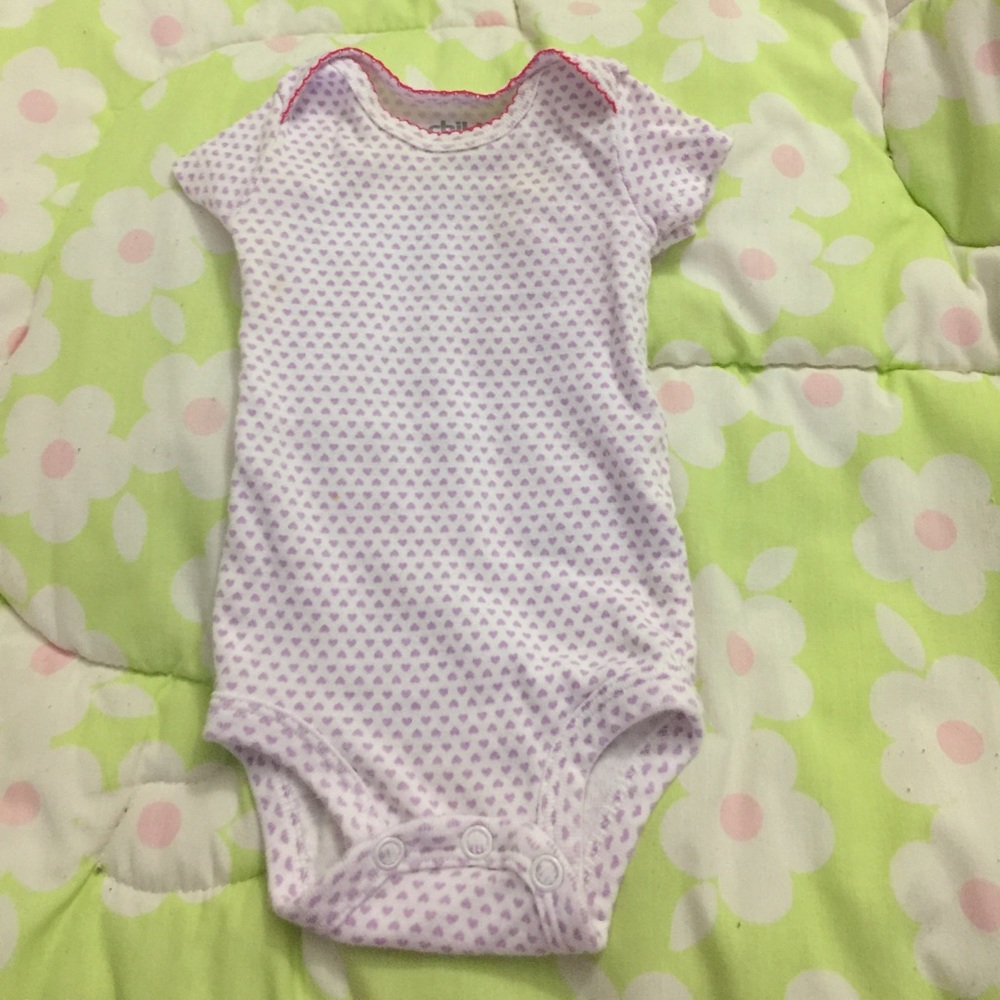 Purple Heart onesie with pink trim at neckline.