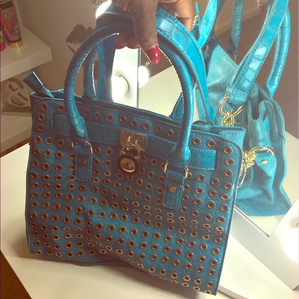 Turquoise shoulder bag with gold accents on it