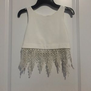 White crop top with lace cuts at the bottom