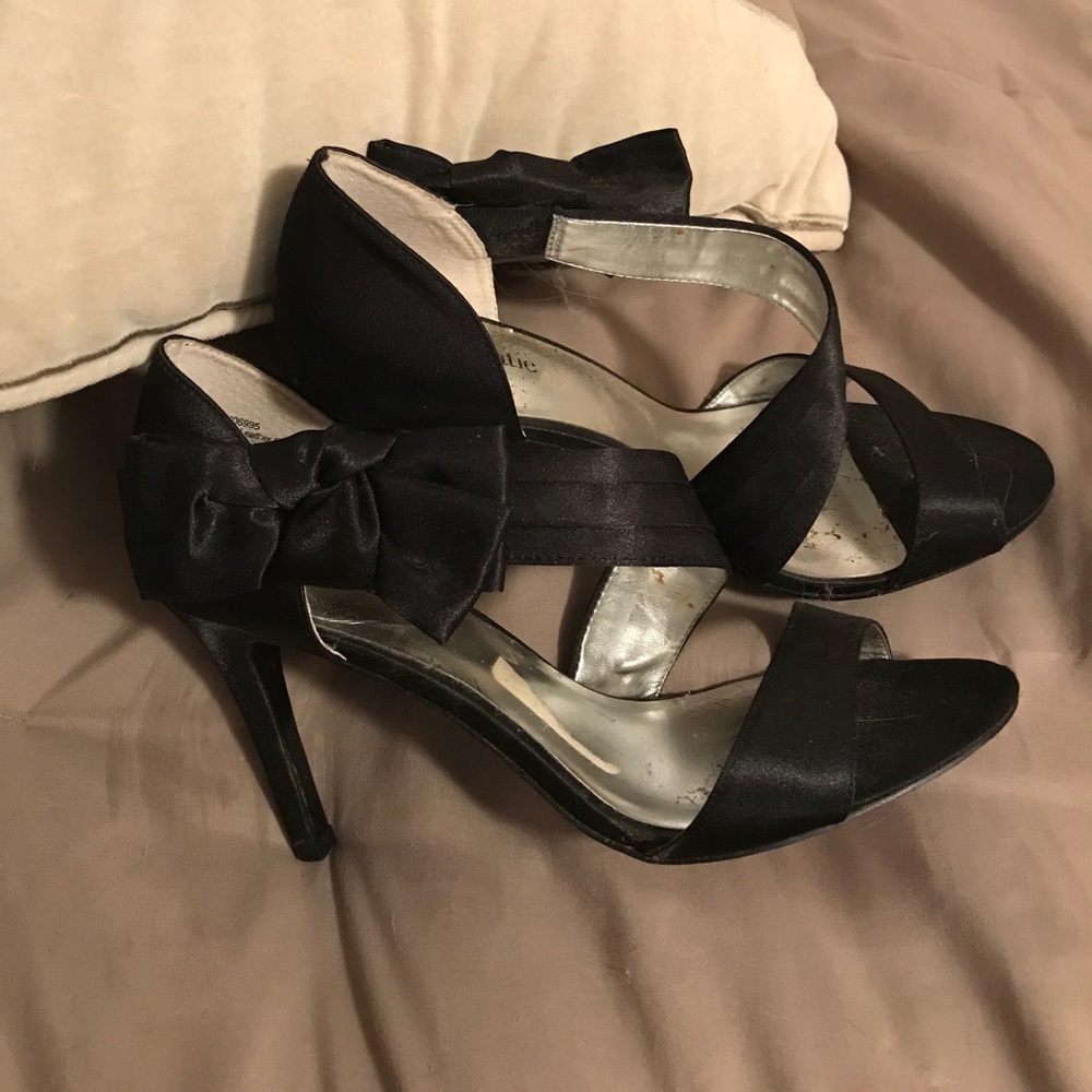 Black high heel shoes with bows.