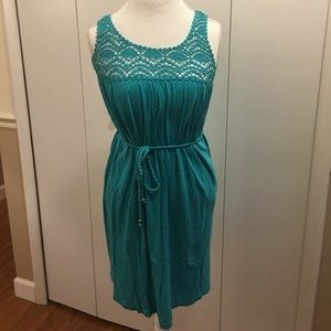 Sleeveless teal dress with belt.