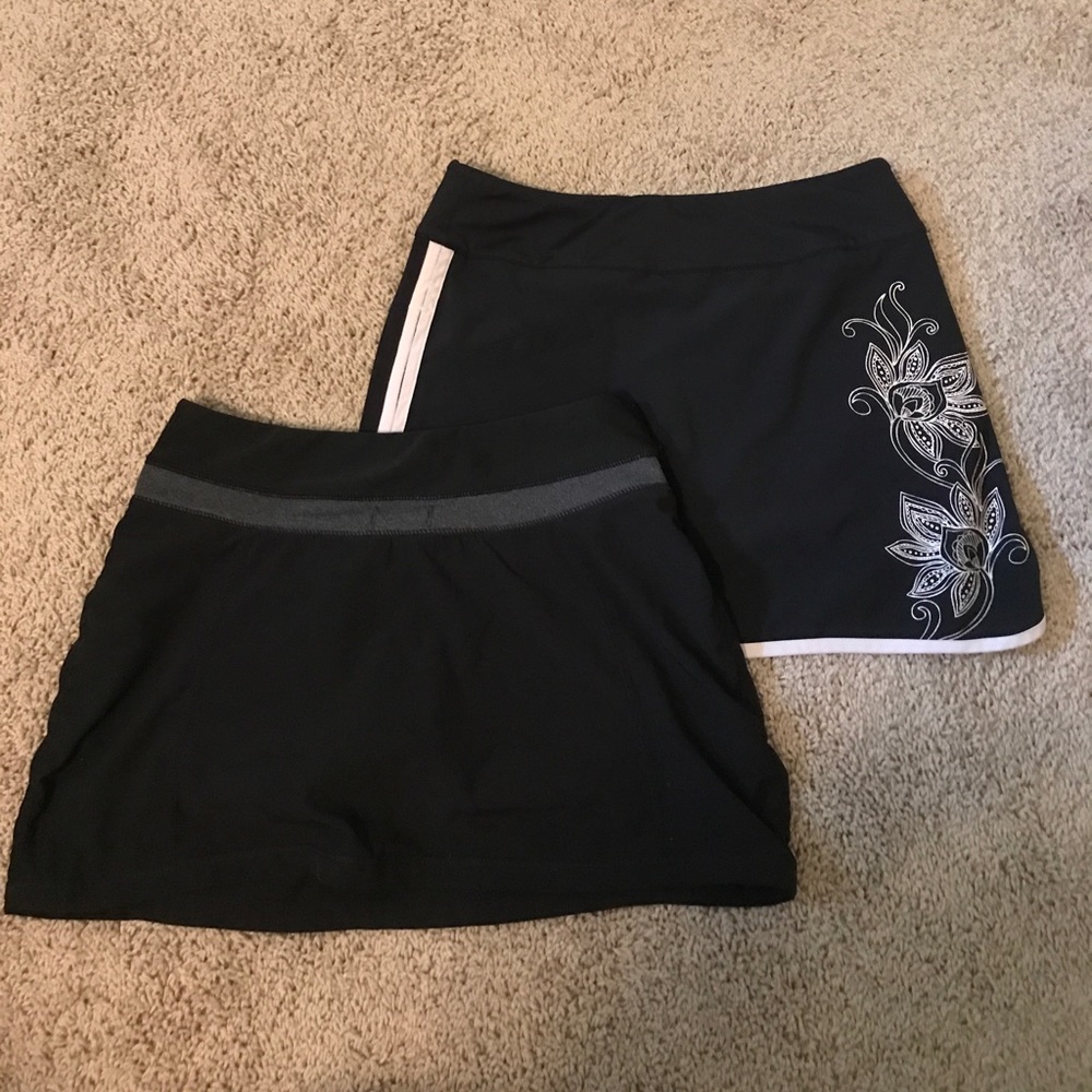 2 black running skirts with integrated shorts.