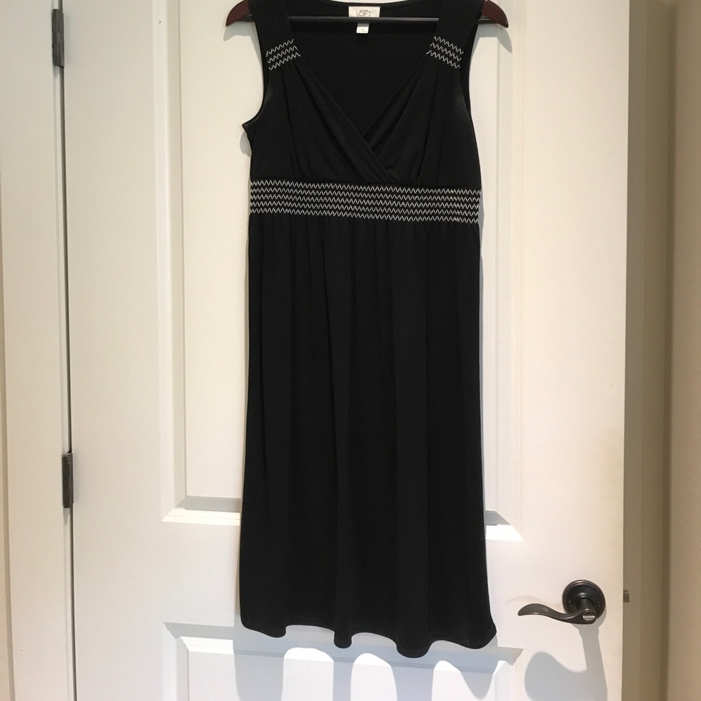 Cute black sleeveless dress with white stitching.