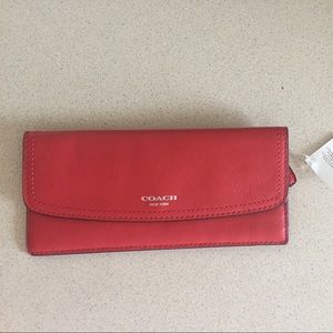 Unused red Coach leather wallet.