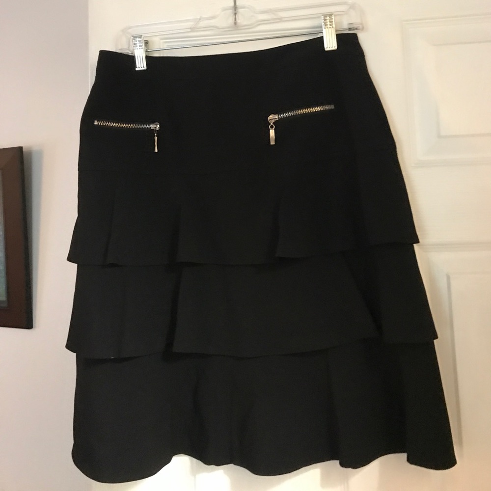 Black ruffled skirt with zippered pockets.