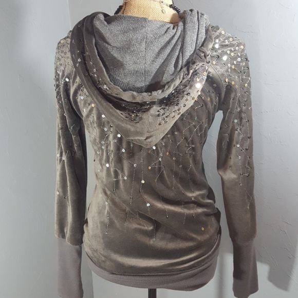 Shop by category Sexy black long sleeve jacket with sequined hood, front zipper and sequin pockets with satin details. (Shorts not included.).