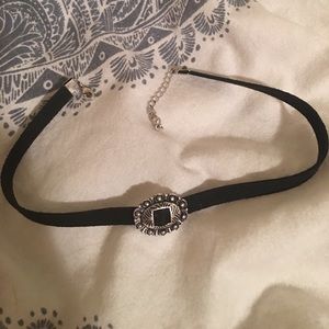 Black choker with silver pendant on front