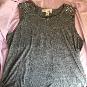 Gray muscle tee with embroidered sleeves.