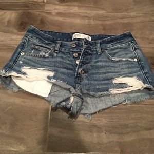 denim shorts with rips and silver buttons