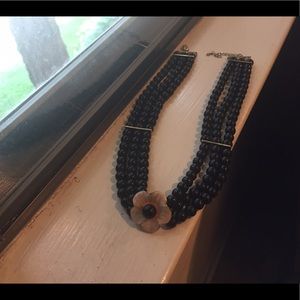 Black bead necklace with white flower
