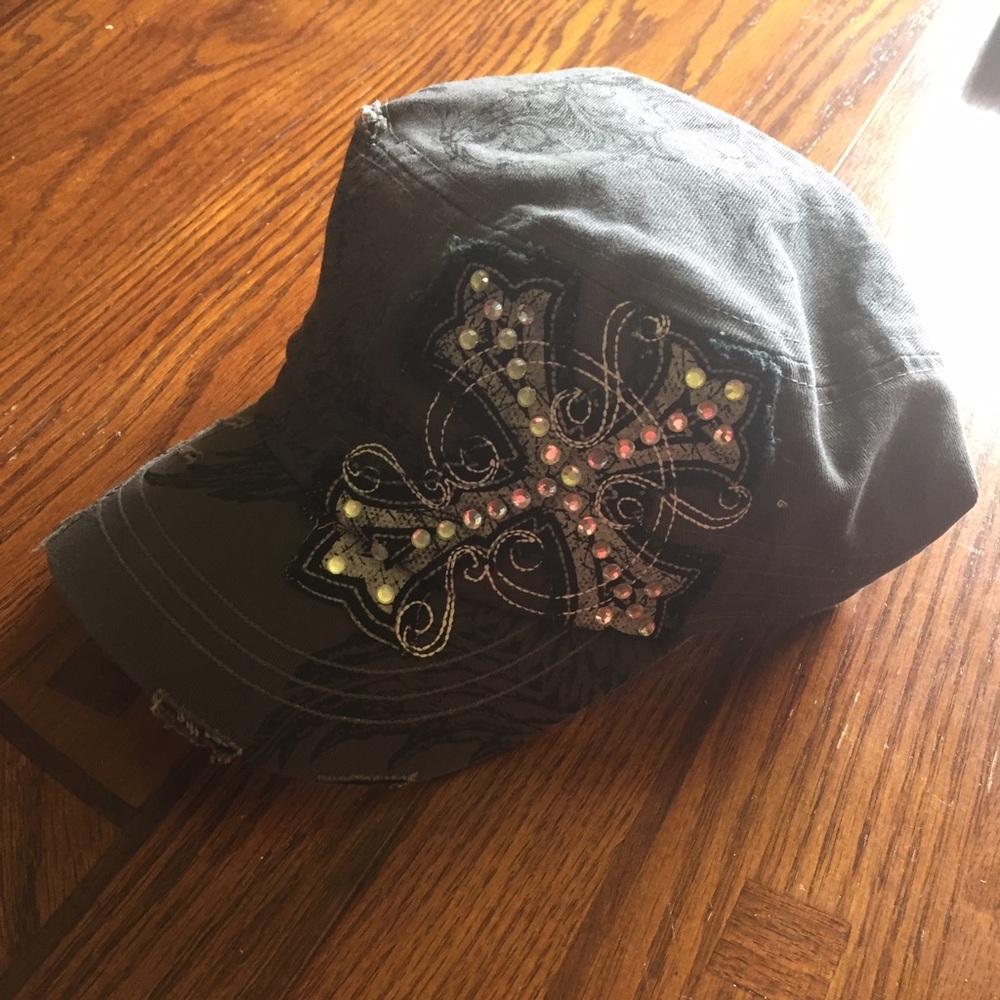 Cadet style hat with cross design on it.