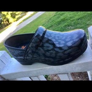 Dansko XP iridescent cheetah print clogs.