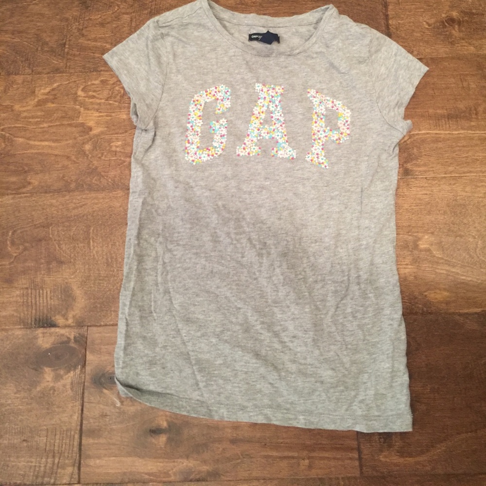 A gray t shirt that says GAP with flowers