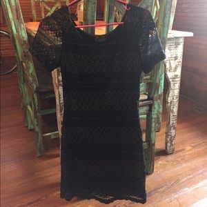 Black lace bodycon dress with gold stitching.