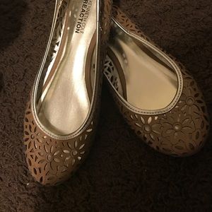 brown flats with gold trim and flower cut outs