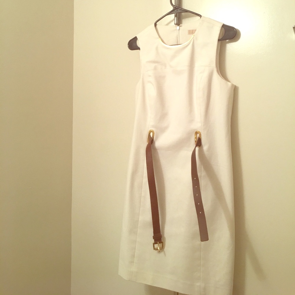 White sleeveless dress with gold trimming.