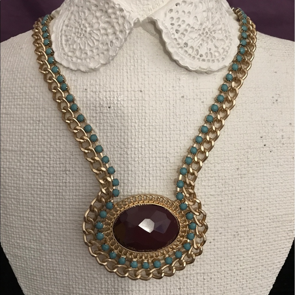 A brown stone with gold chain necklace.
