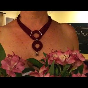 Maroon necklace with silver charms.