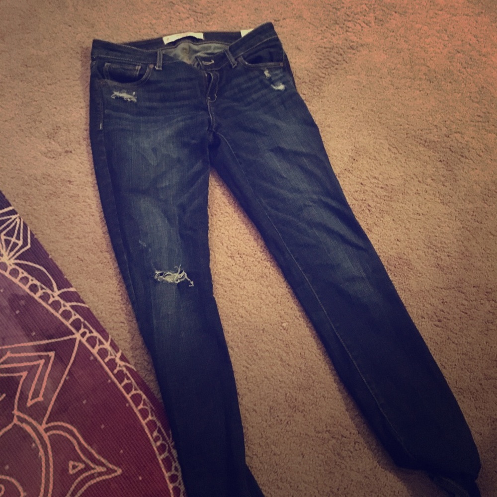 Abercrombie dark wash jeans with decorative tears.