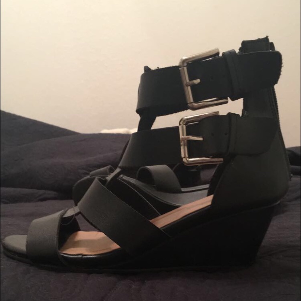 black pair of wedges with buckles on the sides