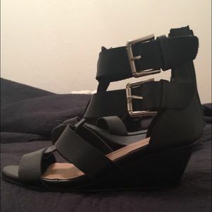 black pair of wedges with buckles on the sides