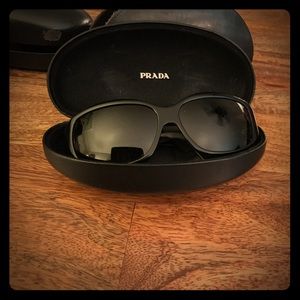 Black framed dark lens Prada sunglasses