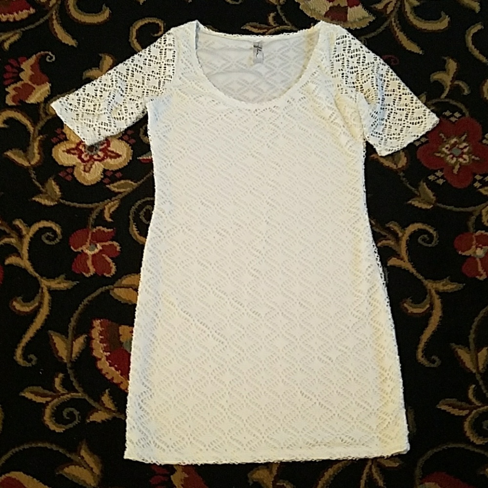 Short white dress with chunky lace-like overly.