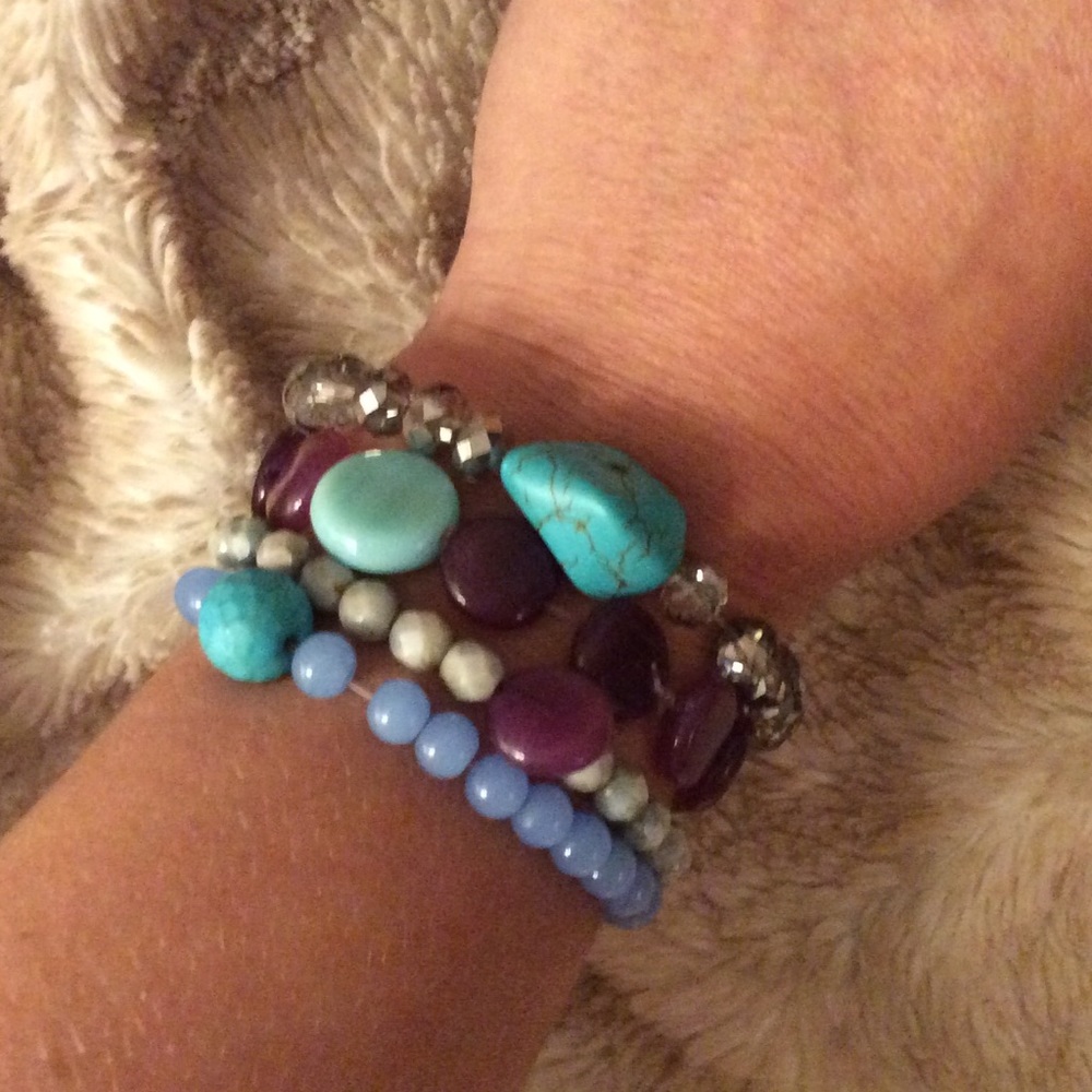 Unique stacked beaded bracelets with charms.