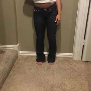 True religion boot cut jeans with pink stitch.