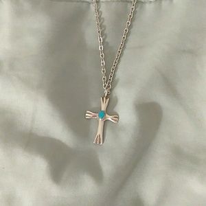 Turquoise cross with silver chain.