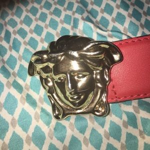 Red Versace belt with gold medusa head buckle.