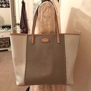 Tan, cream, and troupe coach tote