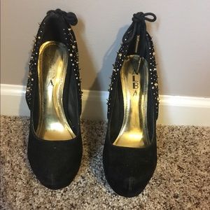 Black suede stiletto heels with gold studs.