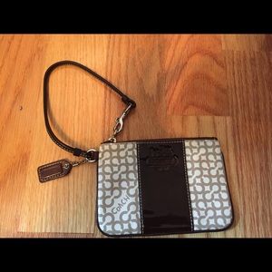 Tan, brown, and white leather Coach wristlet