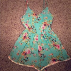Turquoise floral romper with lace trim.