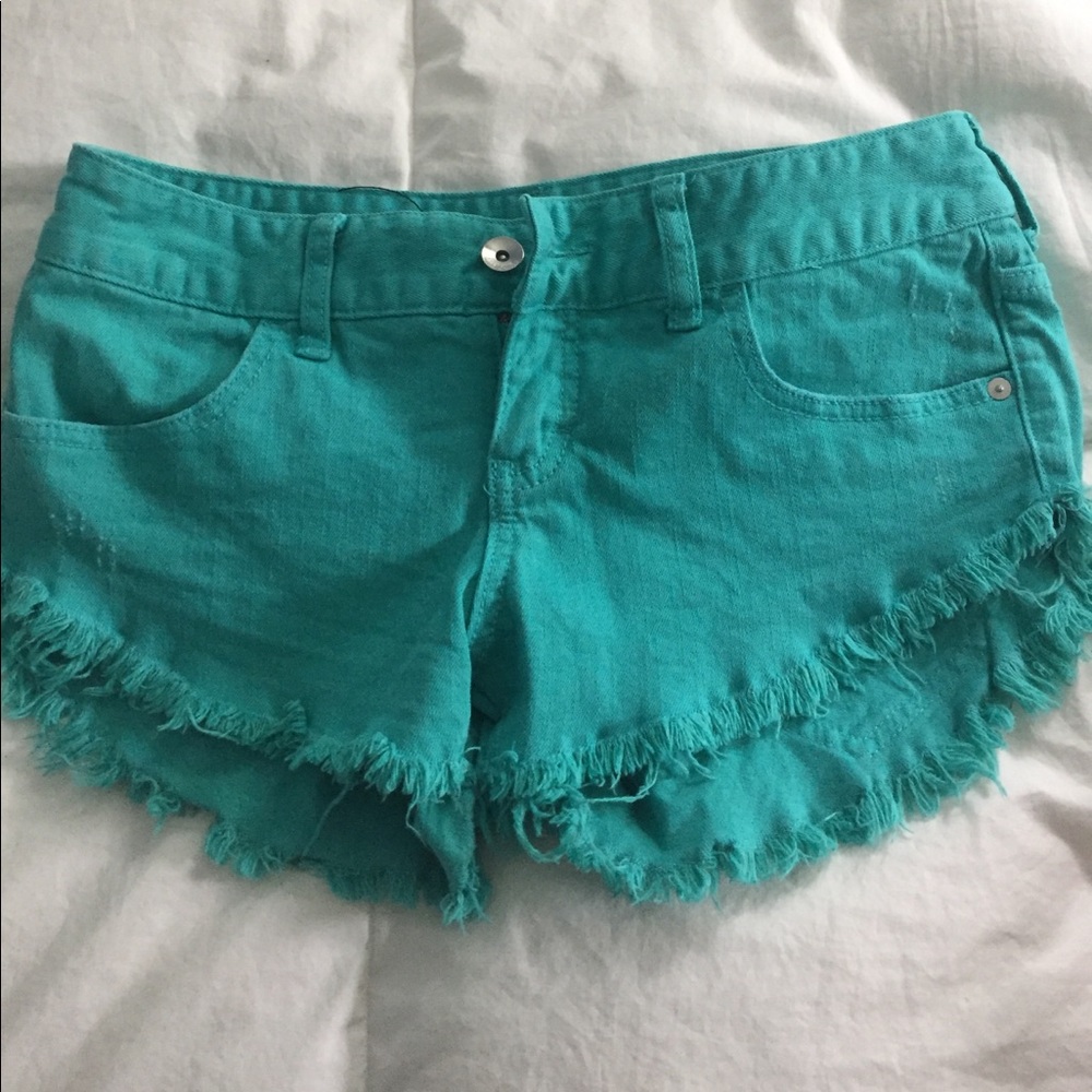 Lightly worn teal denim frayed shorts.