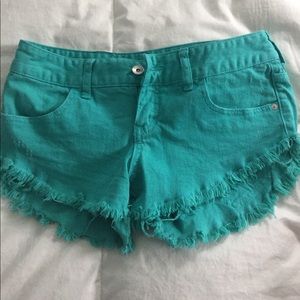Lightly worn teal denim frayed shorts.