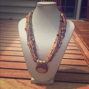 Multi strand amber colored pendant necklace