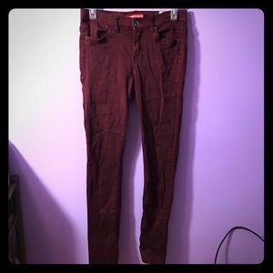 Maroon skinny jeans.