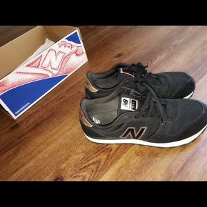 Black white and gold New Balance sneakers.