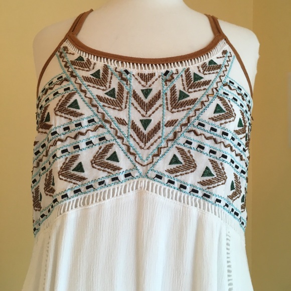 A white dress with pretty designs on the front. - Picture 3 of 6