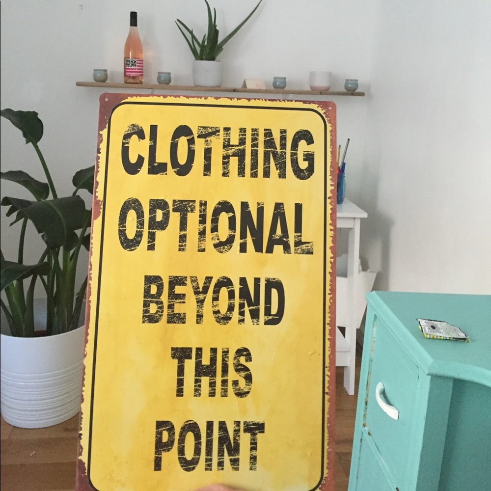 "Clothing optional beyond this point" metal sign