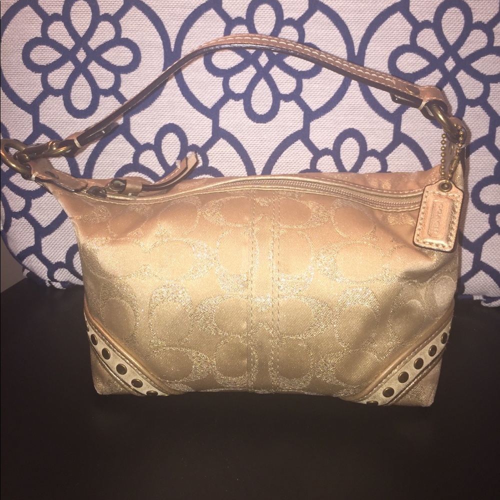 Gold COACH mini purse with detailing on sides.