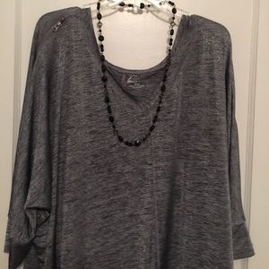 Glittering black top has zippers down both sleeves