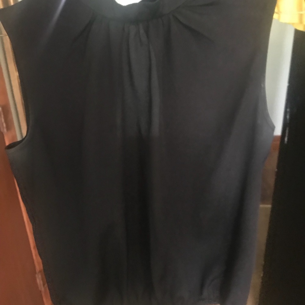 Black polyester sleeveless shirt. Low back too
